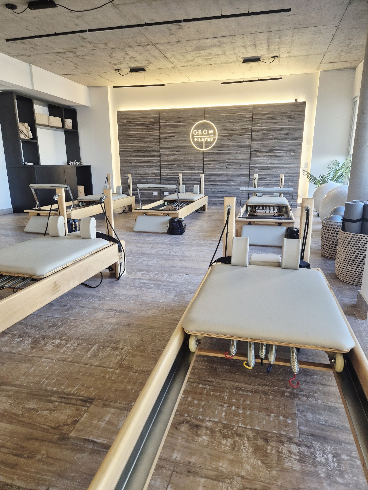 Interior del estudio Grow Pilates Urquiza con reformers de madera y atmósfera cálida